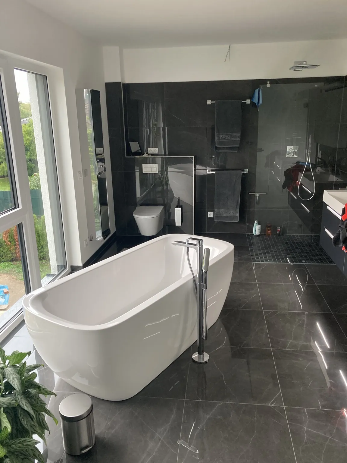 Badezimmer mit großformatigen dunklen Boden- und Wandfliesen