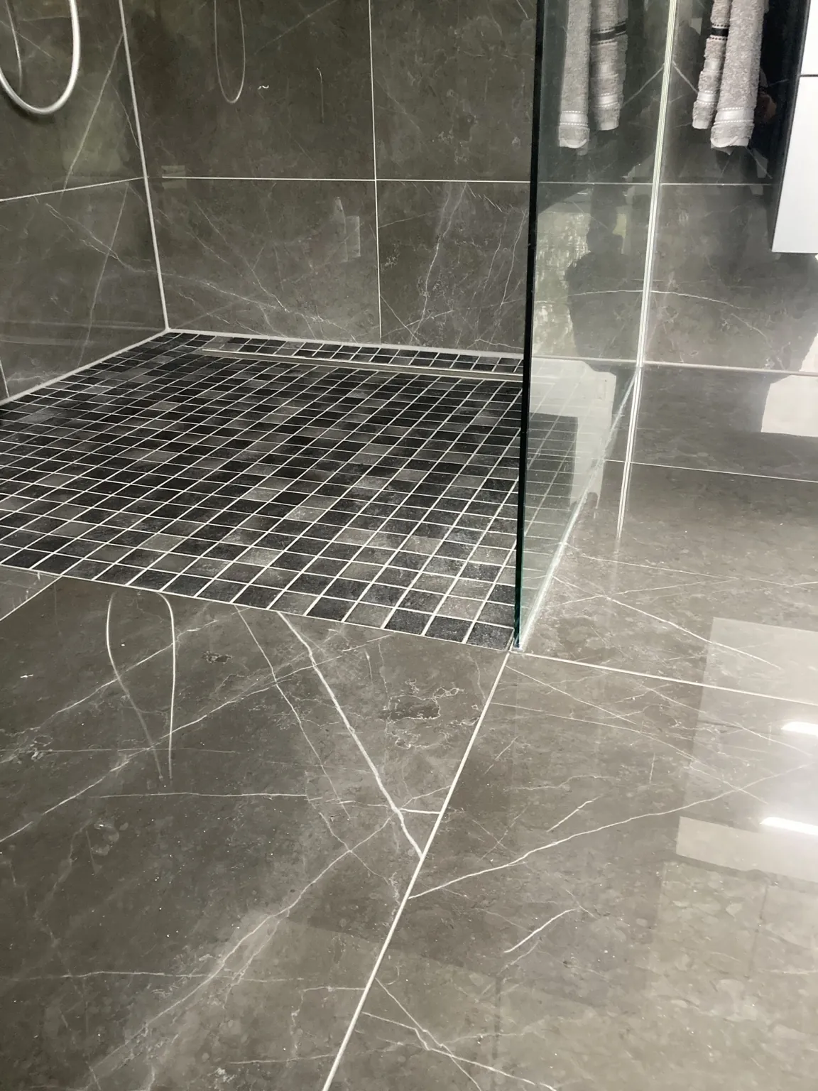 Bodengleiche Dusche mit Mosaikboden und Linienrinne